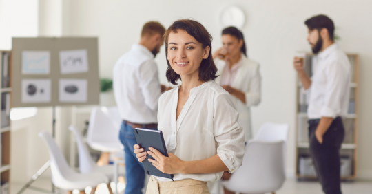 Kobieta w pracy podczas spotkania biznesowego wpatrzona w odbiorcę.